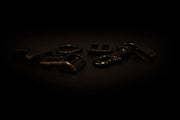Set aus schwarzen Metallschnallen, Karabinern und Beschlägen auf dunkler Oberfläche